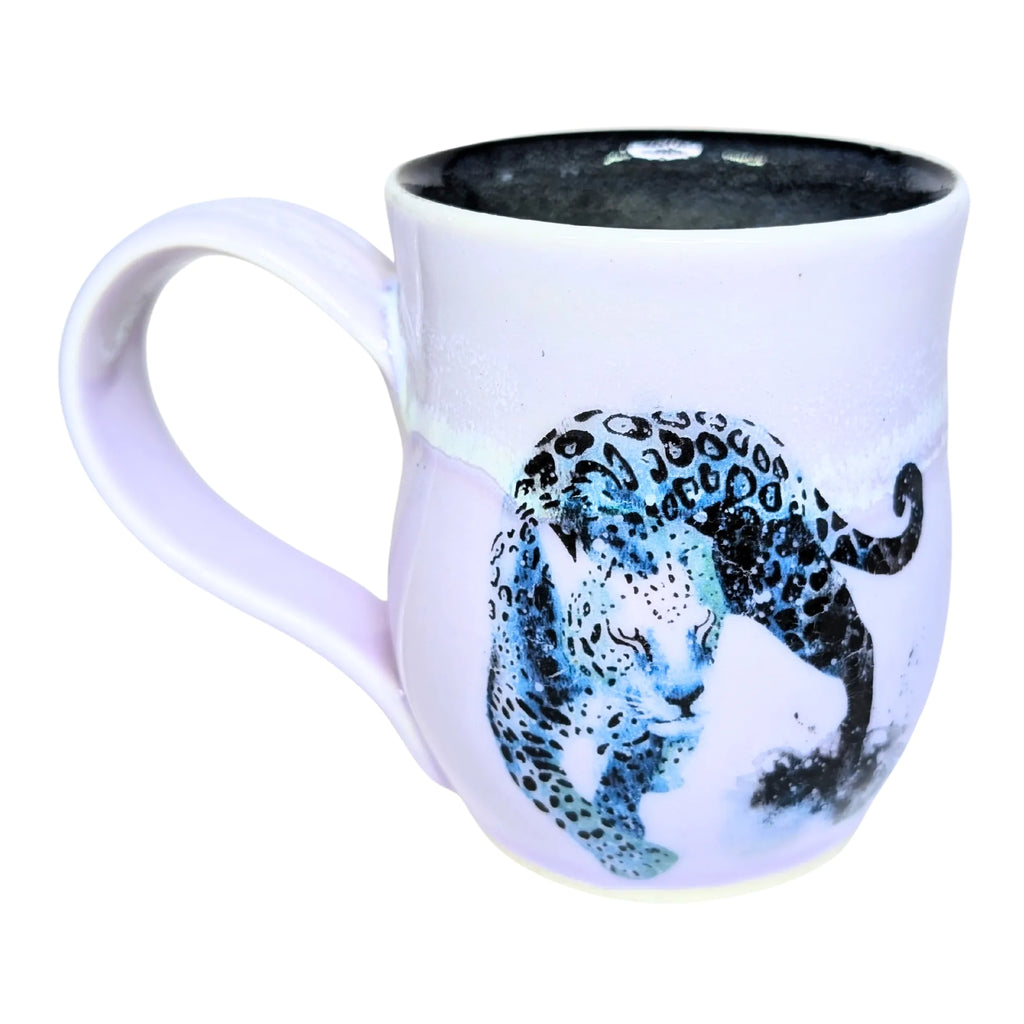 White mug with a black and blue leopard design on a white background