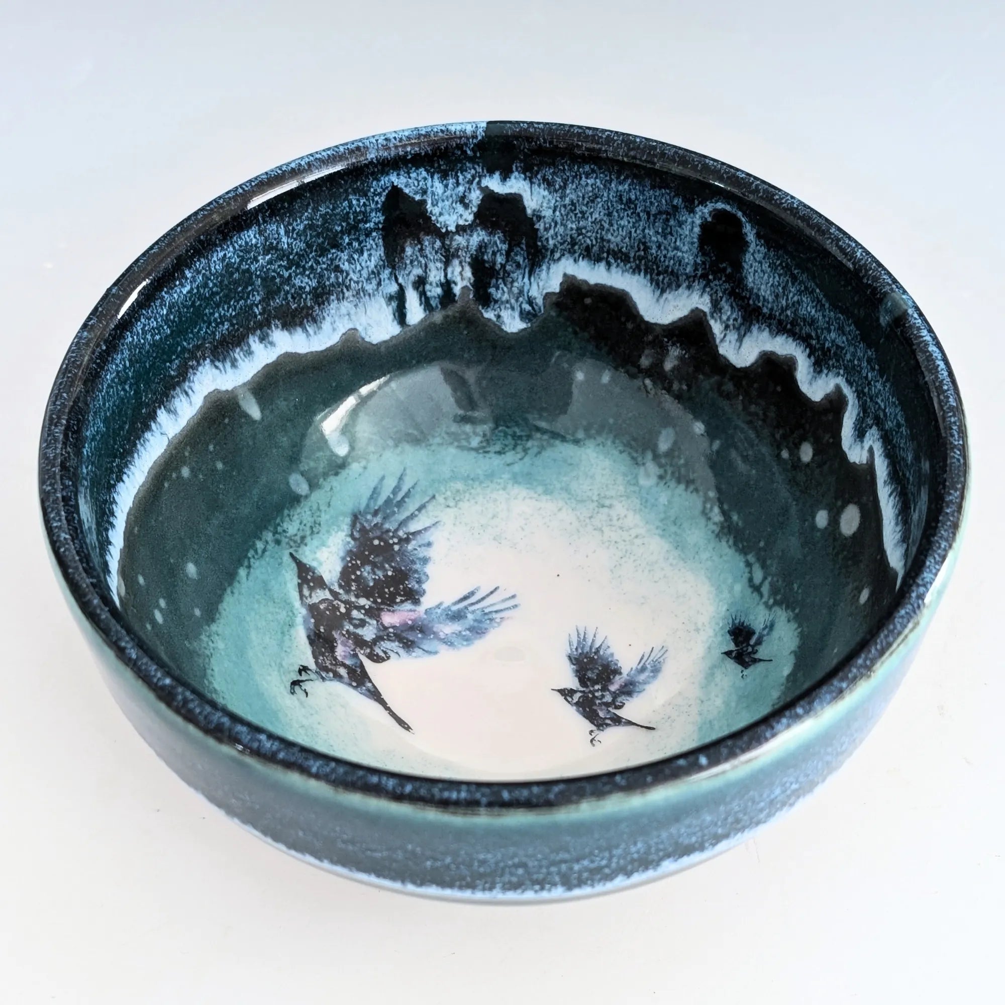 Ceramic bowl with bird illustrations on a white background